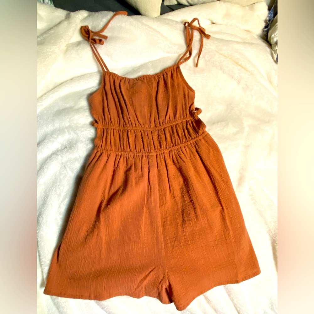 Romper size small. Red/orange in color almost like a rust color. Never worn.